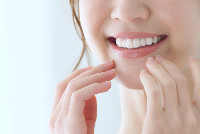 歯を見せて笑う女性の口元