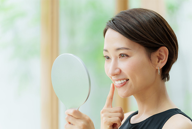 鏡で歯をチェックする女性
